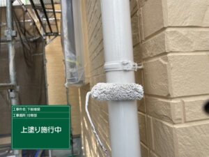 泉大津市S様邸の雨樋塗装で上塗りを施工している様子